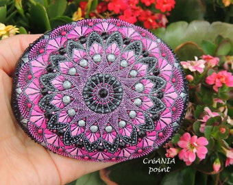 Colorful dotted mandala in dot painting on hand painted stone