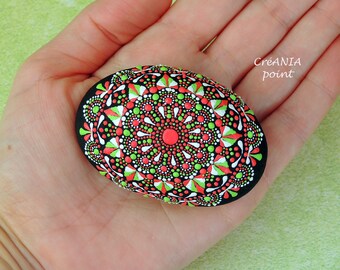 Dot painting mandala on hand painted rock in red, green and white