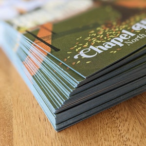 A detail shot of the postcards shows the quality of the cardstock and the blue core around the edge of the postcard