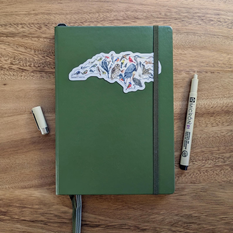 Birds of NC sticker shown on a small notebook