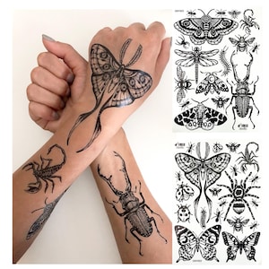 May include: A sheet of black and white temporary tattoos featuring various insects and arachnids including moths, butterflies, a scorpion, a beetle, a spider, and bees. The designs are shown applied to skin, displaying a moth, scorpion, and beetle.