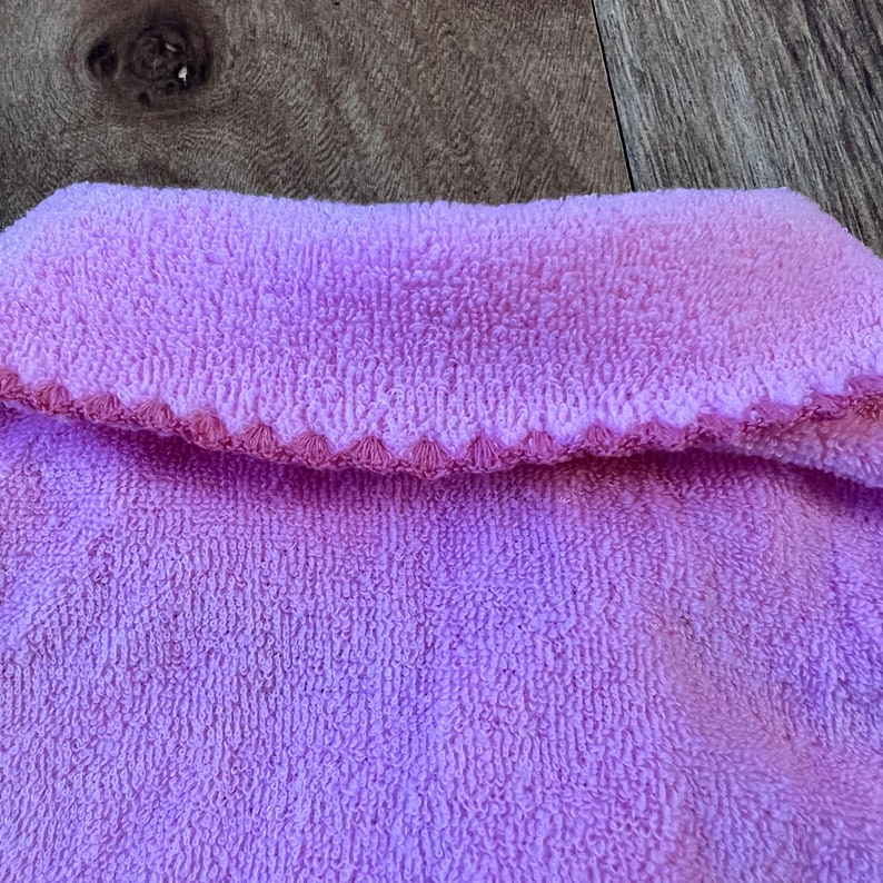 May include: A close-up of a soft, light purple towel with a textured surface.