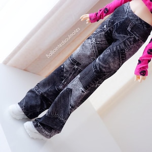 Könnte beinhalten: Schwarz-graue Hose im Denim-Stil mit einem Patchwork-Design. Die Hose wird mit einem langärmeligen, pinkfarbenen Oberteil mit schwarzen Totenkopf-Grafiken getragen. Weiße Turnschuhe vervollständigen das Outfit. Der Text "balljointedsoulmates" ist sichtbar.