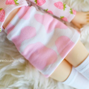 Peut inclure: Une jupe rose et blanche &agrave; motif c&oelig;ur. La jupe est faite d'un tissu doux et extensible et a une coupe confortable.