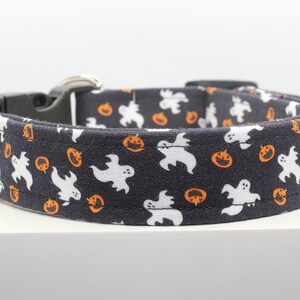 May include: A black dog collar with a white and orange pattern of ghosts and pumpkins.