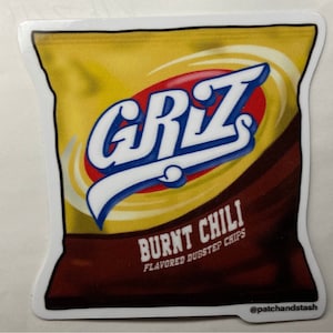 May include: A sticker of a yellow and brown chip bag with the word "GRIZ" in white letters with blue outlines. The bag says "Burnt Chili Flavored Dubstep Chips" and has the social media handle "@patchhandstash" at the bottom.