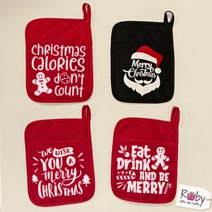 May include: Four red and black quilted pot holders with white Christmas-themed designs. The designs include "Christmas Calories Don't Count", "Merry Christmas", "We Wish You A Merry Christmas", and "Eat Drink And Be Merry".