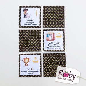 May include: Six black and gold cards with Arabic text and illustrations. The cards feature images of a boy with a sheep, a person trimming hair, a trophy, and a pattern. The text on the cards includes the words "udhiyyah", "taqsir al shaear", "thawab", and "أضحية".