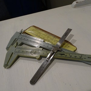 Conjunto de medidas vintage; dois paquímetros de hardware ACO, conversor métrico de bolso Sterling e medidor de profundidade ACO, coleção de ferramentas de engenharia vintage