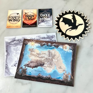 Puede incluir: Tres libros de bolsillo con imágenes de dragones en las portadas. Los libros se titulan "Fourth Wing", "Iron Flame" y "Onyx Storm". Los libros son de Rebecca Yarros. Un mapa de una tierra ficticia con una silueta de dragón en el fondo.