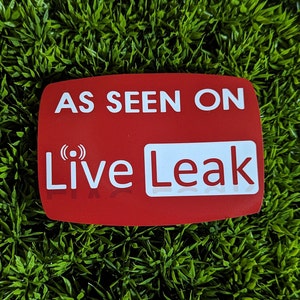 May include: Red rectangular sticker with white text that reads "As Seen On Live Leak" with a small radio wave icon above the word "Live".