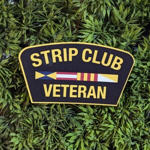 May include: A black and yellow patch with the text "Strip Club Veteran" and a nautical flag design.