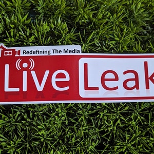 May include: Red and white sticker with the text "Live Leak" and the words "Redefining The Media" above it.