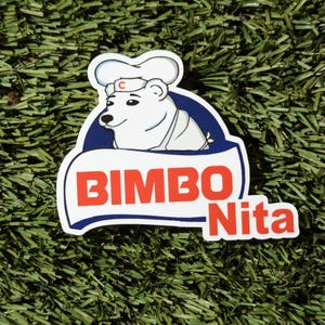 May include: A white polar bear wearing a chef's hat with a red 'C' on it. The bear is holding a blue and white sign that says "BIMBO Nita" in red letters.