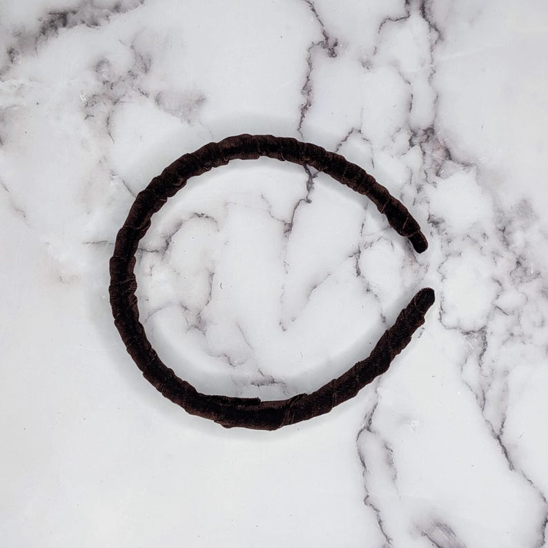 chocolate brown velvet padded headband photographed on its side