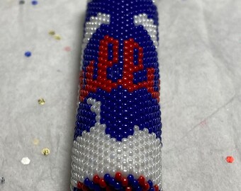 May include: A beaded keychain with a red, white, and blue design. The keychain is made of small beads and has a circular ring at the top.