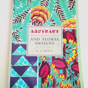 Könnte beinhalten: Ein Buch mit dem Titel "ABSTRACT AND FLORAL DESIGNS" von E. A. Seguy. Das Cover zeigt farbenfrohe Blumen- und geometrische Muster in Türkis, Lila, Gelb und Rosa. Der Titel ist in einer dekorativen Schriftart, und das Cover enthält den Text "WITH FORTY FULL COLOUR PLATES."