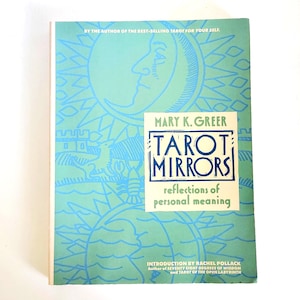 以下が含まれることがあります： メアリー・K・グリア著『Tarot Mirrors: Reflections of Personal Meaning』というタイトルの本。表紙は水色で、太陽、月、風景を描いた濃い青色の線画が特徴です。テキストには「By the author of the best-selling Tarot for Your Self」と記載されています。