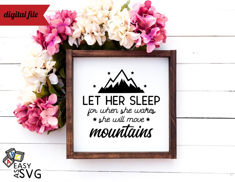 May include: A white sign with a brown wooden frame, featuring a black mountain silhouette with stars and the text "LET HER SLEEP for when she wakes * she will move * mountains".