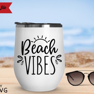 May include: White stainless steel tumbler with a black graphic that says "Beach Vibes" and a sun graphic. The tumbler is sitting on a wooden surface with a pair of sunglasses next to it.