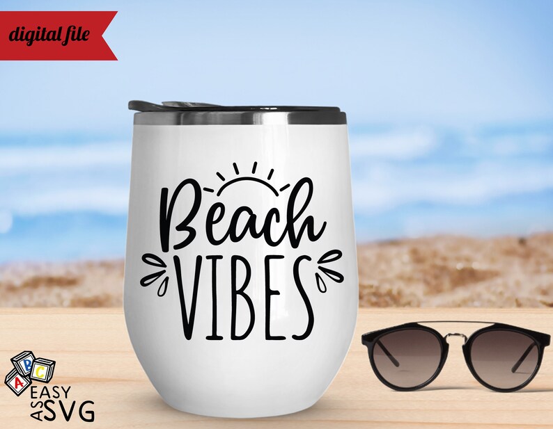 May include: White stainless steel tumbler with a black graphic that says "Beach Vibes" and a sun graphic. The tumbler is sitting on a wooden surface with a pair of sunglasses next to it.