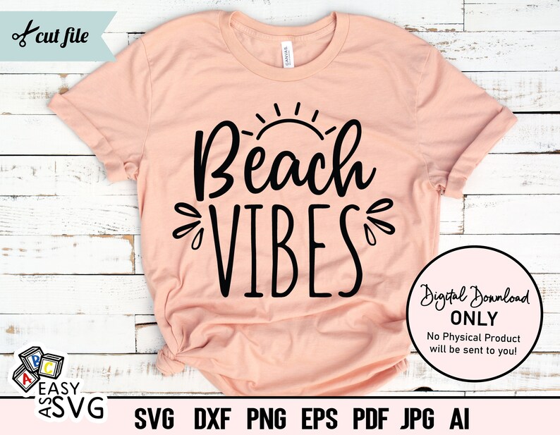May include: A peach-colored t-shirt with the text "Beach Vibes" in black lettering. The text is stylized with a sun graphic above the word "Beach".