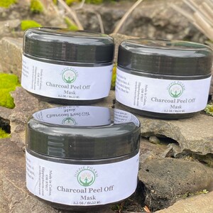 May include: Three black jars of charcoal peel off mask with white labels. The labels have the text "Hippie Pharm" and "Charcoal Peel Off Mask" with the size "2.1 oz / 62.10 ml".