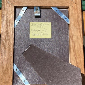 May include: A wooden picture frame with a brown mat and a yellow note attached to the mat. The note reads "Arab of the Desert 1839 Lithograph by David Roberts".