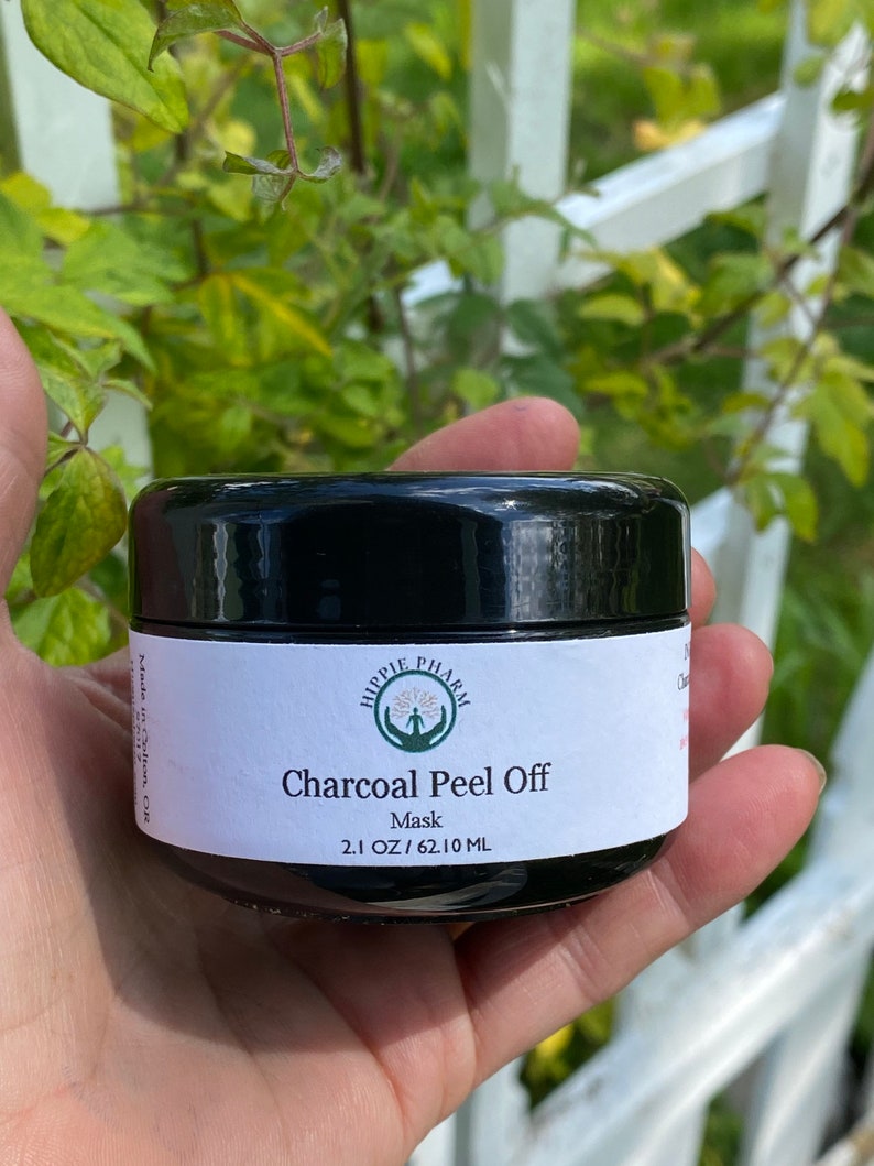 May include: A black jar with a white label that reads "Hippie Pharm Charcoal Peel Off Mask 2.1 OZ/62.10 ML".