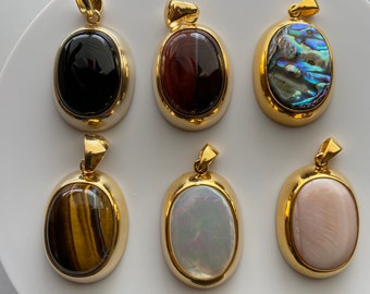 May include: Six gold oval pendants with different gemstone inserts. The pendants are arranged in two rows of three. The gemstones include black onyx, red tiger's eye, abalone shell, tiger's eye, white mother of pearl, and pink mother of pearl.