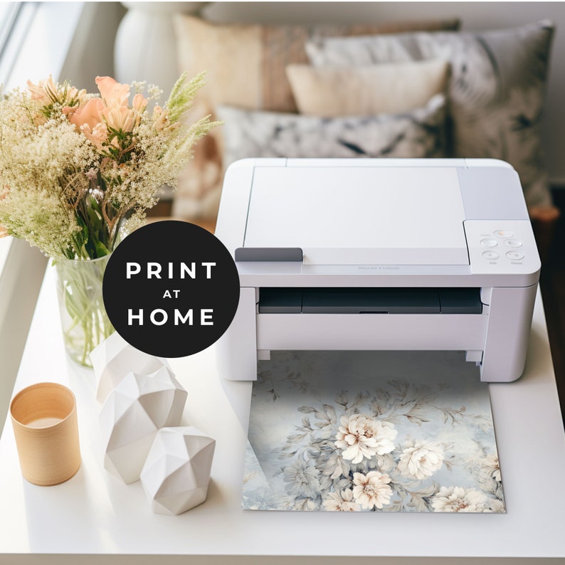 May include: A white printer with a floral print coming out of the paper tray. The print is a light blue background with white and beige flowers. The text "PRINT AT HOME" is on a black circle in the foreground.