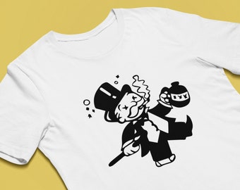 May include: A white t-shirt with a black and white illustration of the Monopoly Man holding a bottle of whiskey and a cane.
