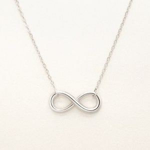 May include: A silver infinity symbol necklace with a delicate chain.