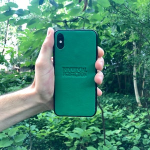 May include: A green leather phone case with the text "INDIVIDUAL PERFECTION" embossed on the back.