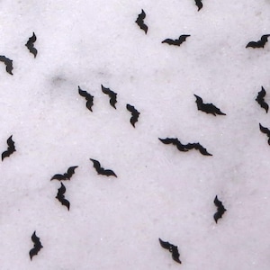 May include: A white background with black bat silhouettes scattered across the surface.