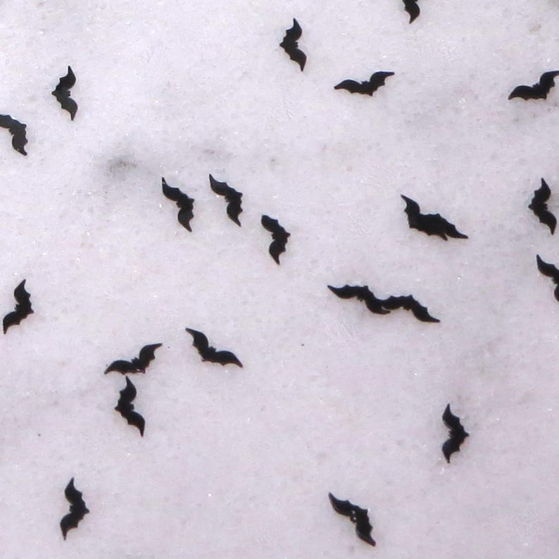 May include: A white background with black bat silhouettes scattered across the surface.