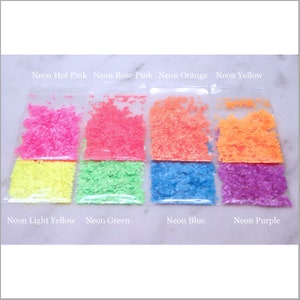 May include: Eight small bags of neon colored glitter. The colors are hot pink, rose pink, orange, yellow, light yellow, green, blue, and purple.