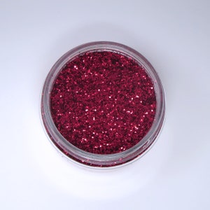 May include: A small jar filled with deep red glitter.