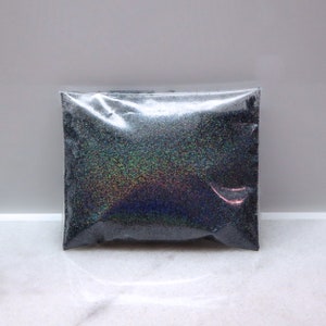 May include: A small clear plastic bag filled with black iridescent glitter.