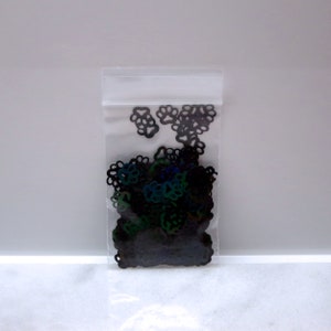 May include: A clear plastic bag filled with black iridescent paw print shaped confetti.