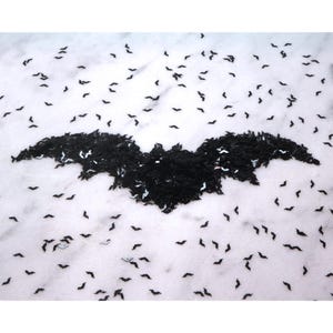 May include: A black bat shape made from small black bats on a white background.