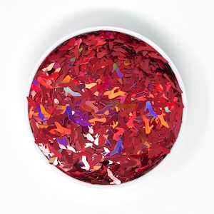 May include: A white bowl filled with red iridescent glitter shaped like high heels.