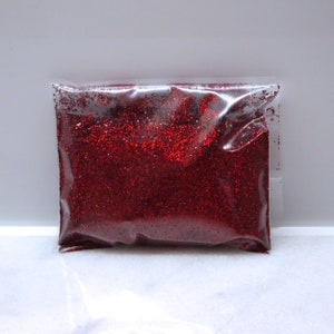 May include: A clear plastic bag filled with red glitter.