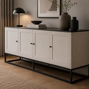 Può includere: Una credenza rettangolare dotata di quattro ante color bianco sporco con piccoli pomelli neri, un piano superiore grigio scuro e una base con telaio in metallo nero. L'unità è posizionata orizzontalmente e presenta un design a quattro pannelli.