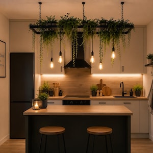 Könnte beinhalten: Eine Küche mit einem von der Decke hängenden schwarzen Metallregal, das mit grünen Hängepflanzen und vier Edison-Glühbirnen bestückt ist. Darunter befindet sich eine dunkle Kücheninsel mit zwei Holzhockern und einer hellen Arbeitsplatte aus Holz.