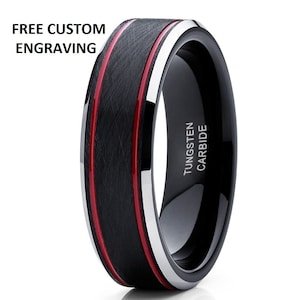 May include: Black tungsten carbide ring with a brushed finish and two red lines around the band. The ring is engraved with "TUNGSTEN CARBIDE".