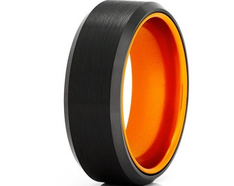 May include: A black tungsten carbide ring with an orange inner band. The ring has a brushed finish and a beveled edge.