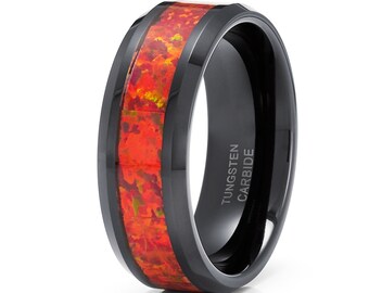 May include: Black tungsten carbide ring with a red and orange opal inlay. The ring is beveled and has the words "Tungsten Carbide" engraved on the inside.