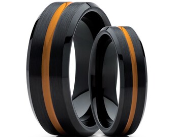 May include: Two black tungsten carbide rings with a single orange stripe around each band.