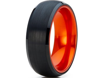 May include: A black tungsten carbide ring with an orange inner band. The ring has a brushed finish and a beveled edge.
